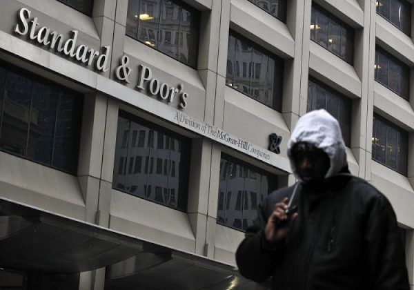 A man walks past the Standard & Poor's building in New York's financial district February 5, 2013. The U.S. government is seeking more than $5 billion in a lawsuit against rating agency Standard & Poor's over mortgage bond ratings, U.S. Attorney General Eric Holder said on Tuesday. The civil suit against S&P and its parent McGraw-Hill Cos Inc is the first federal enforcement action against a credit rating agency over alleged illegal behavior related to the 2007-2009 U.S. financial crisis. REUTERS/Brendan McDermid (UNITED STATES - Tags: BUSINESS CRIME LAW POLITICS) - RTR3DE5O